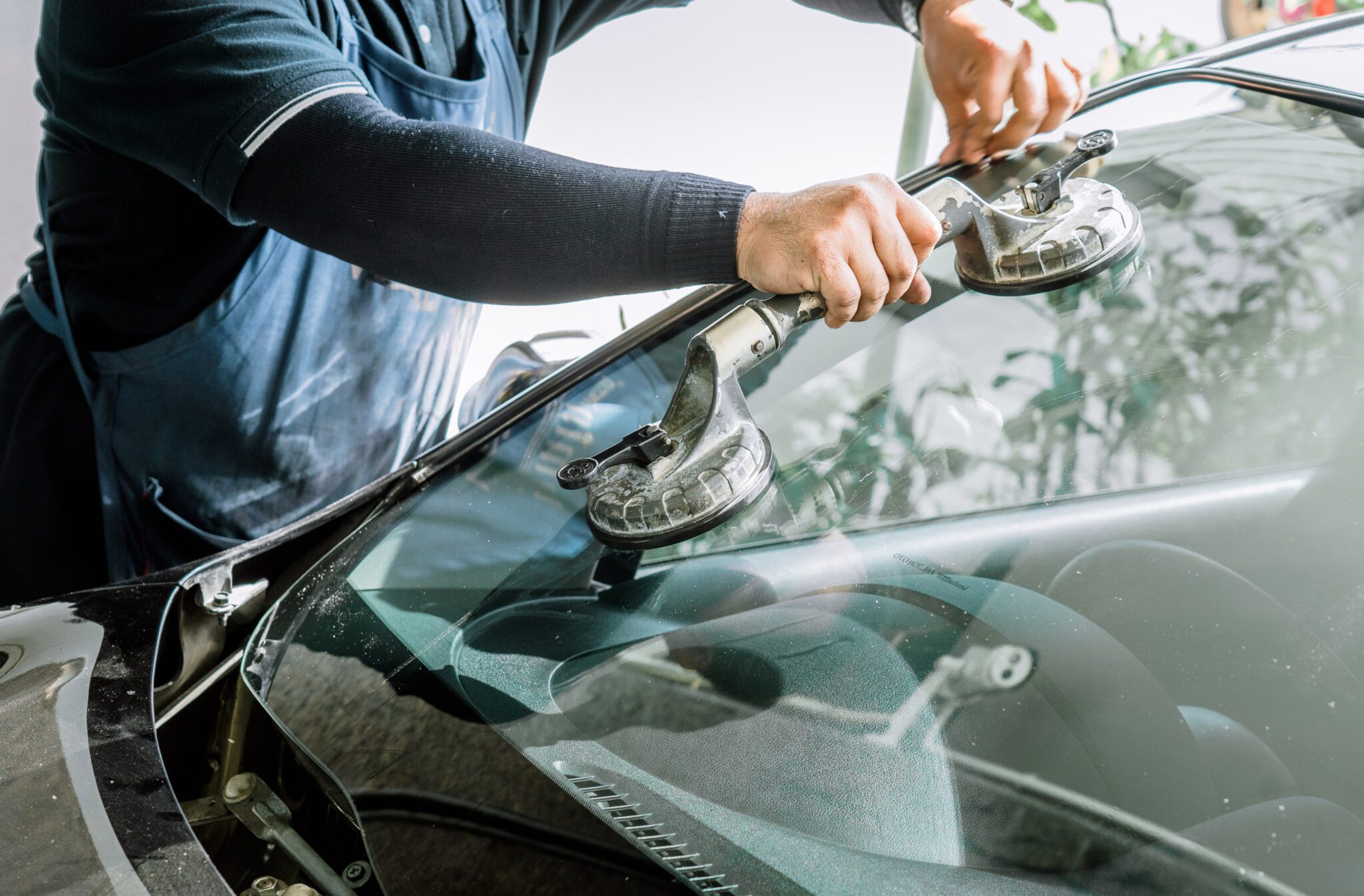 Contractor replacing windshield closeup