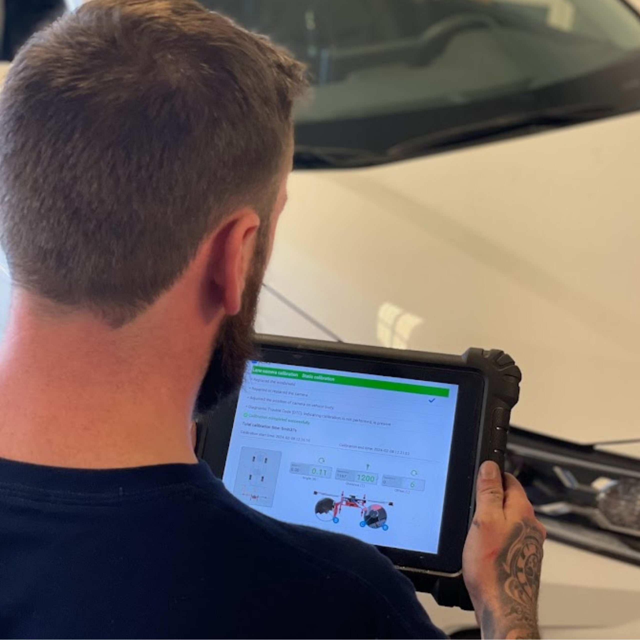 A GoGlass technician recalibrating a vehicle's ADAS